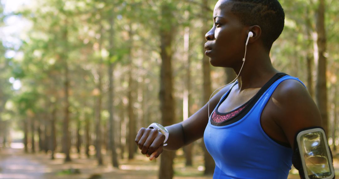 Active Woman Checking Fitness Tracker in Forest - Free Images, Stock Photos and Pictures on Pikwizard.com