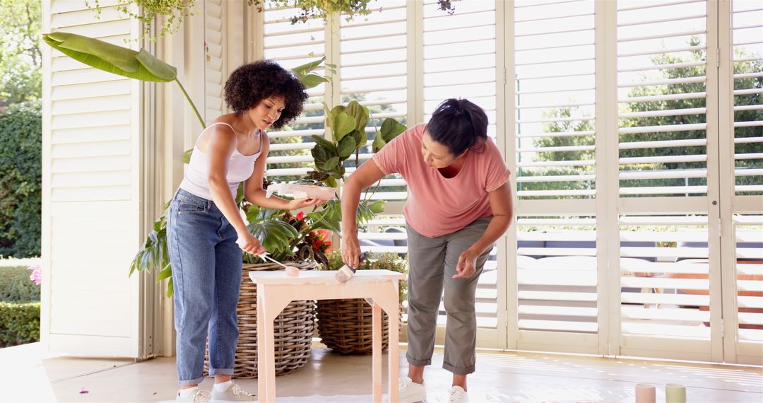 Mother and Daughter Collaborating on DIY Furniture Painting Project
