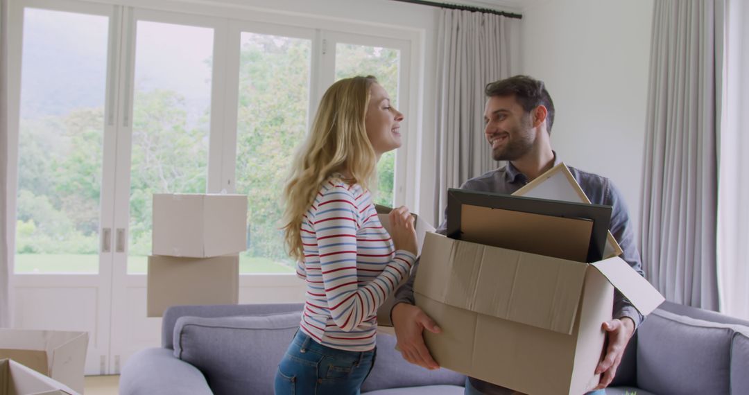 Happy caucasian couple carrying cartons at new home - Free Images, Stock Photos and Pictures on Pikwizard.com