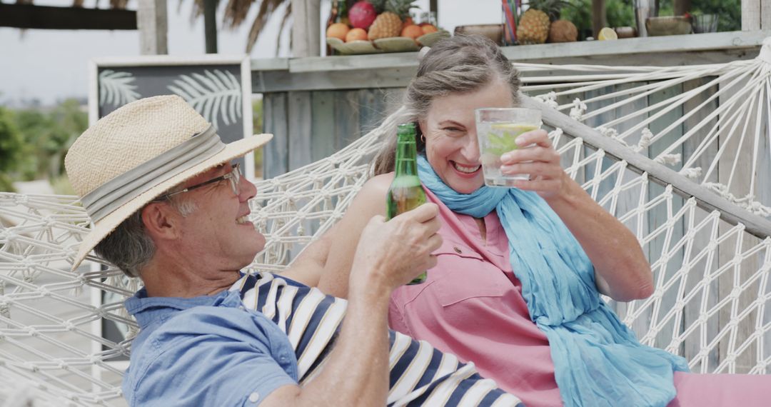 Senior Caucasian Couple Relaxing with Drinks in Hammock