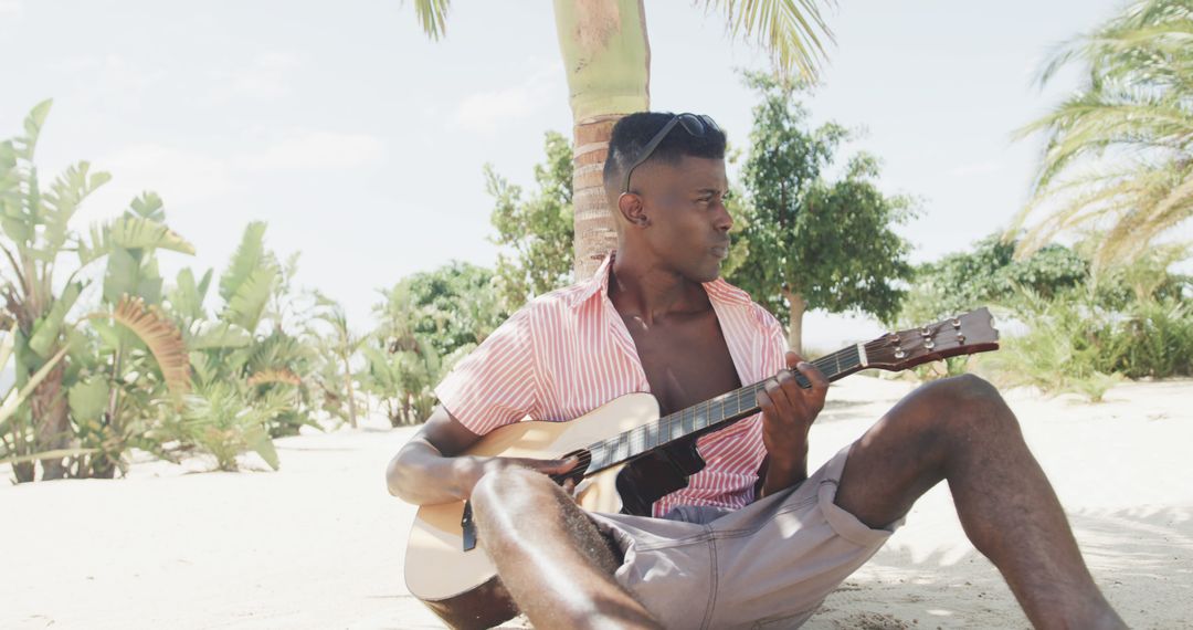 Young Man Playing Guitar on Tropical Beach - Free Images, Stock Photos and Pictures on Pikwizard.com