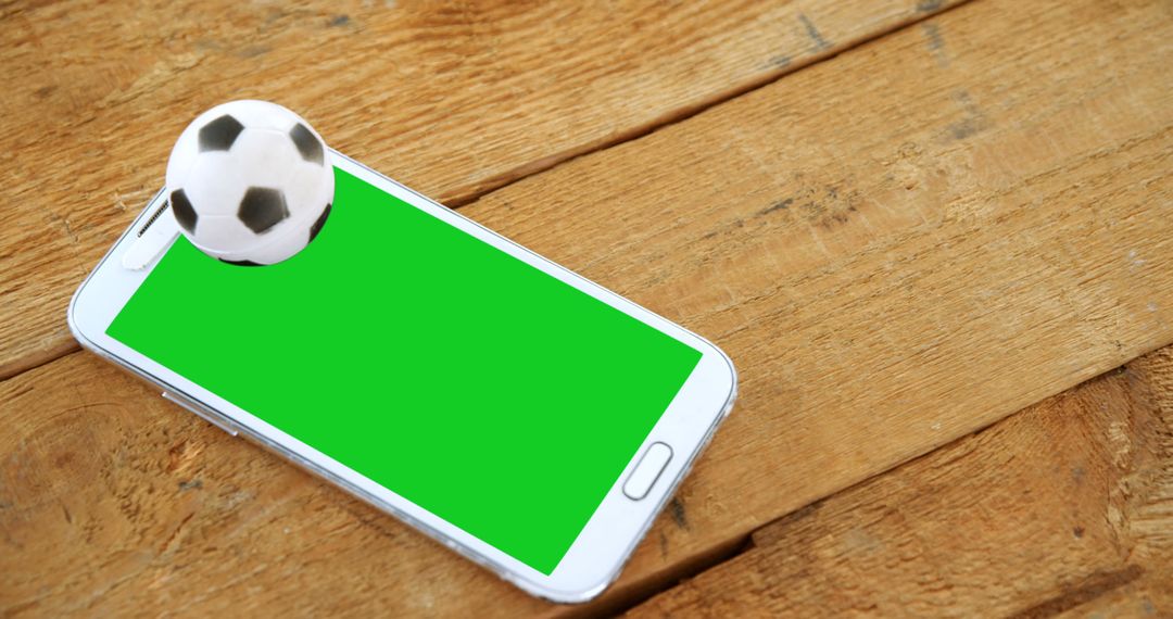 Soccer Ball Bouncing Out of Smartphone Screen on Wooden Table - Free Images, Stock Photos and Pictures on Pikwizard.com