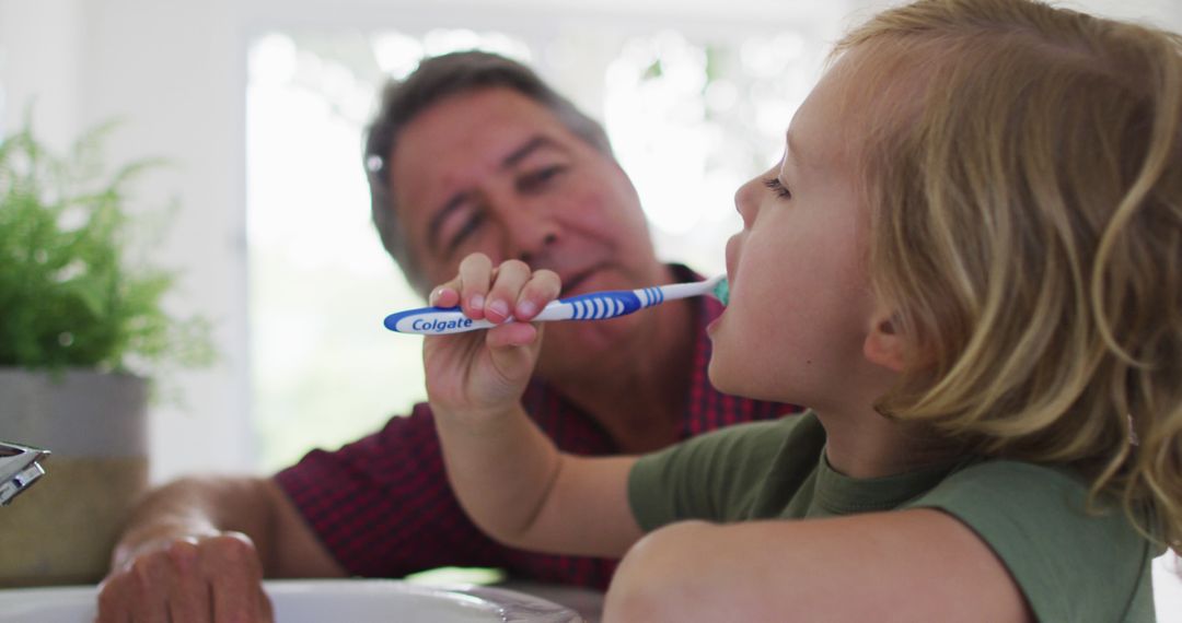 Caucasian grandfather helping his grandson to brush his teeth at home - Free Images, Stock Photos and Pictures on Pikwizard.com