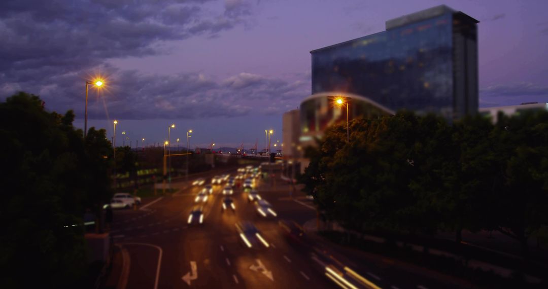 Dusk Traffic Flow Creating Light Trails on Multilane Urban Road with Glass High-Rise