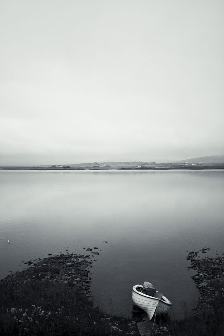 Solitary Rowboat in Misty Lakeside Tranquility - Free Images, Stock Photos and Pictures on Pikwizard.com