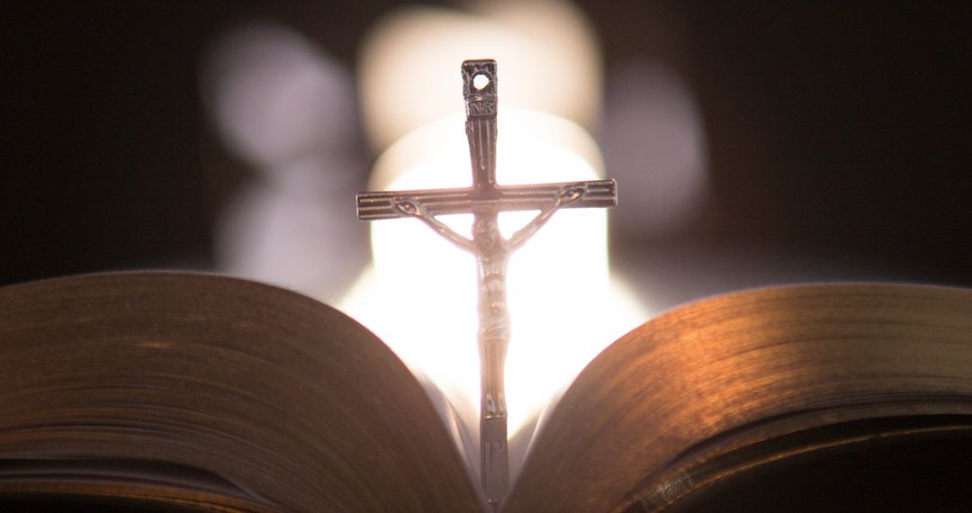 Silhouette of Cross with Open Bible Against Blurred Lights