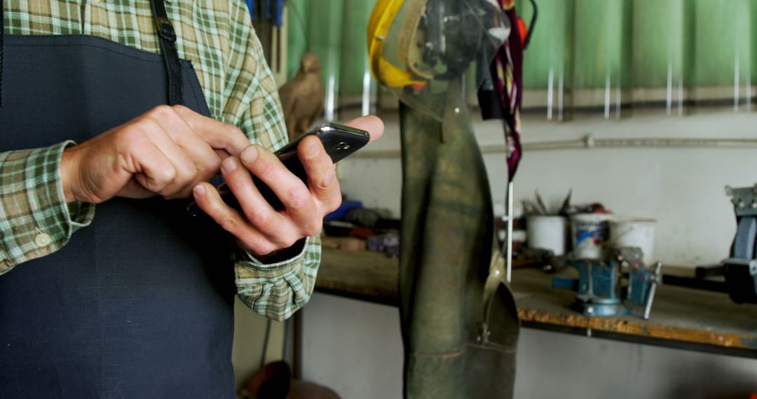 Craftsman Checking Smartphone in Workshop - Free Images, Stock Photos and Pictures on Pikwizard.com