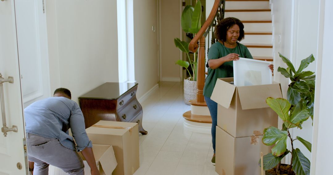 Couple Unpacking and Decorating New Home with Art