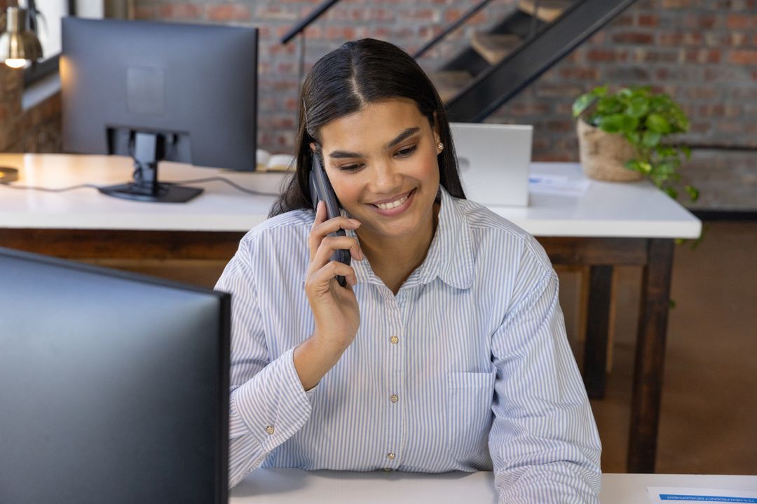 Business Professional Conversing via Smartphone at Modern Desk