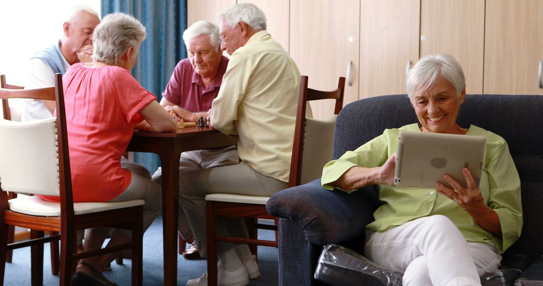 Retirees Playing Board Games While Woman Using Digital Tablet in Retirement Home - Free Images, Stock Photos and Pictures on Pikwizard.com