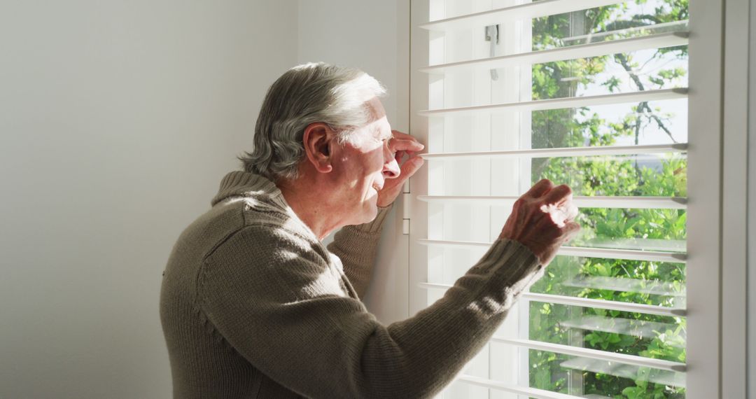 Elderly Man Looking Through Window Blinds at Home - Free Images, Stock Photos and Pictures on Pikwizard.com