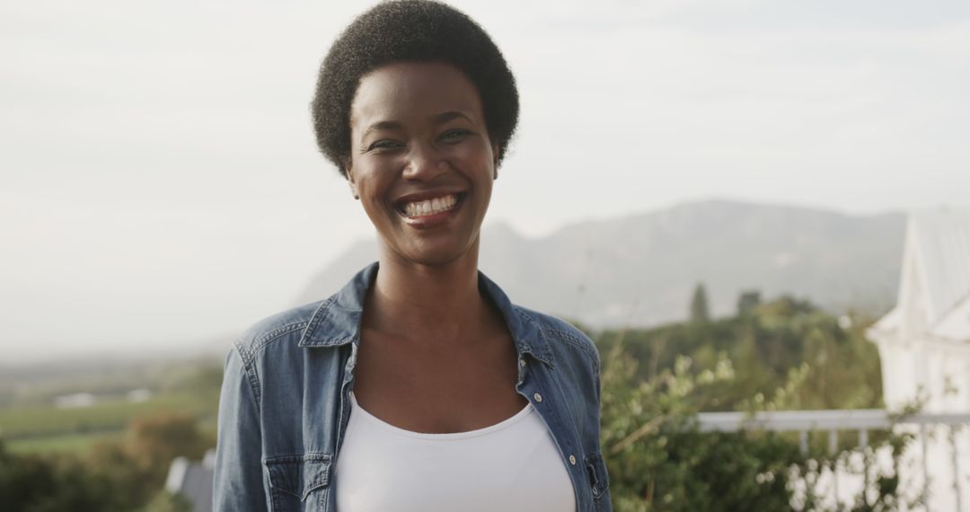 Smiling Woman Standing Outdoors with Scenic Landscape - Free Images, Stock Photos and Pictures on Pikwizard.com