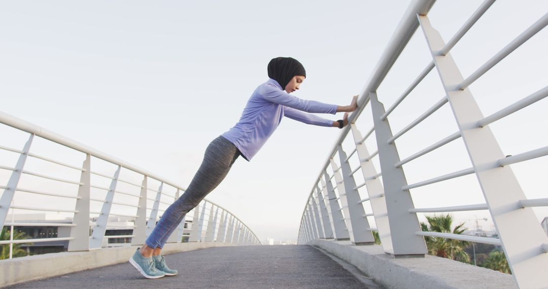 Fit Woman in Hijab Doing Pushups on Bridge at Sunrise - Free Images, Stock Photos and Pictures on Pikwizard.com