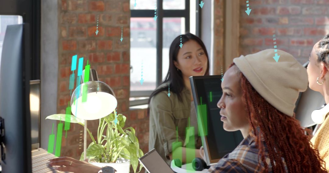 Diverse Women Collaborating at Modern Loft Workspace Using Computers and Creative Planning