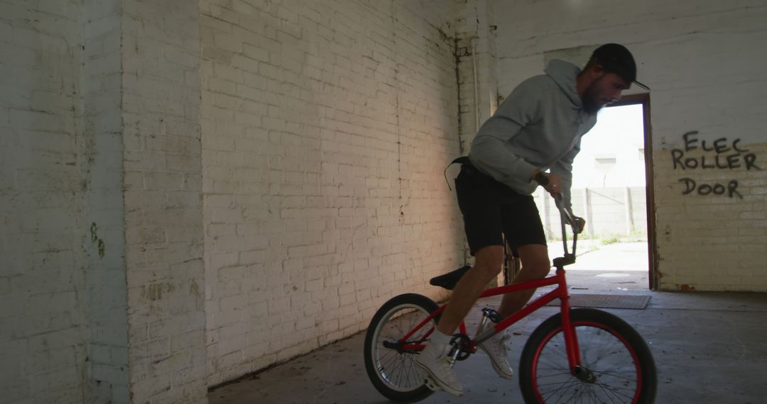 Young Man Performing Bicycle Tricks in Abandoned Building - Free Images, Stock Photos and Pictures on Pikwizard.com