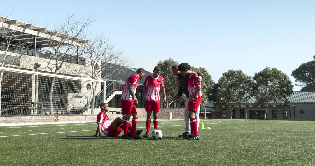 Coach Instructing Young Soccer Players During Practice on Field