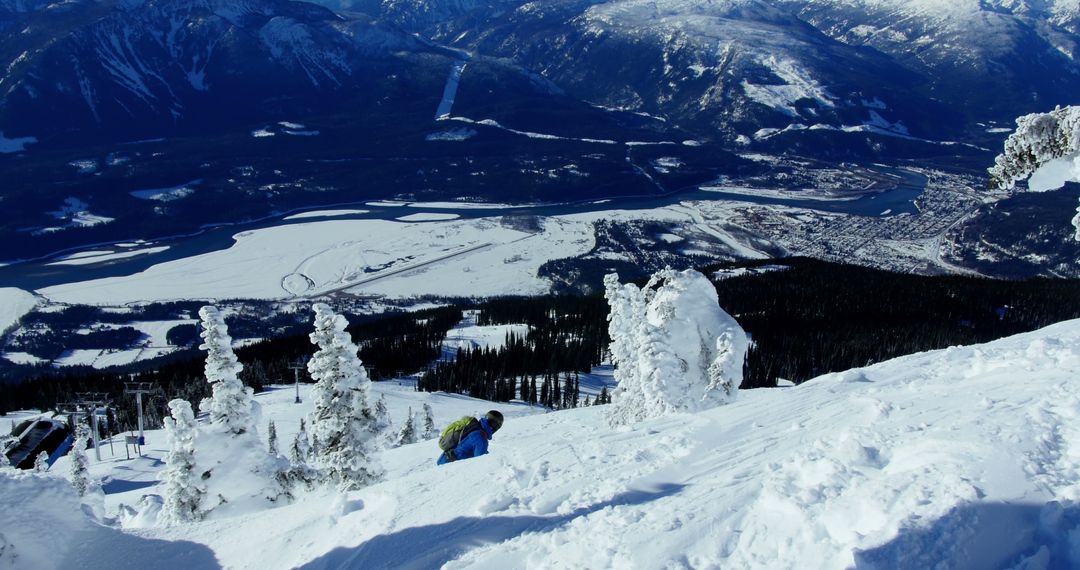 Adventurous Skier Descending Snow-covered Mountain Slope with Scenic View - Free Images, Stock Photos and Pictures on Pikwizard.com