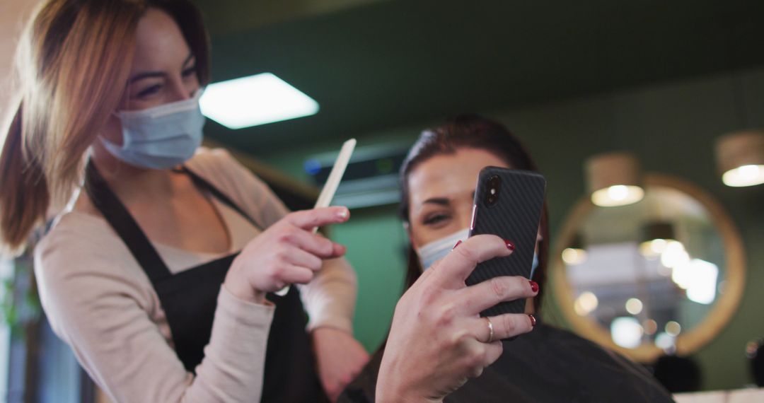 Hairdresser Showing Style to Client on Phone for Hair Transformation - Free Images, Stock Photos and Pictures on Pikwizard.com