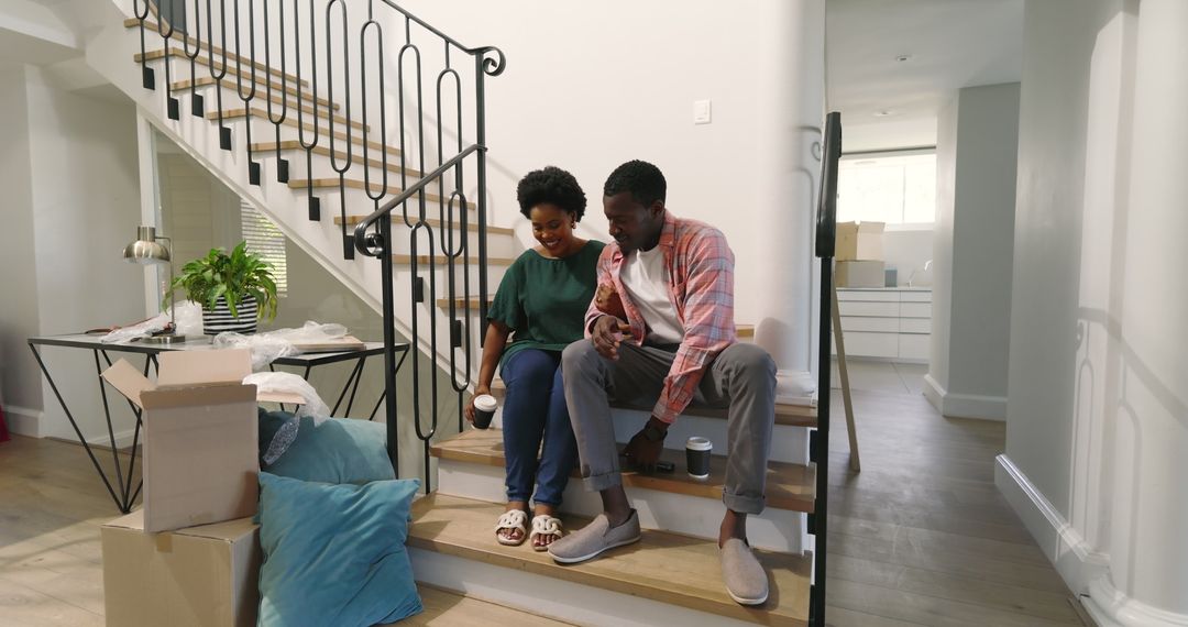 Happy Couple Unpacking and Enjoying Coffee in New Home