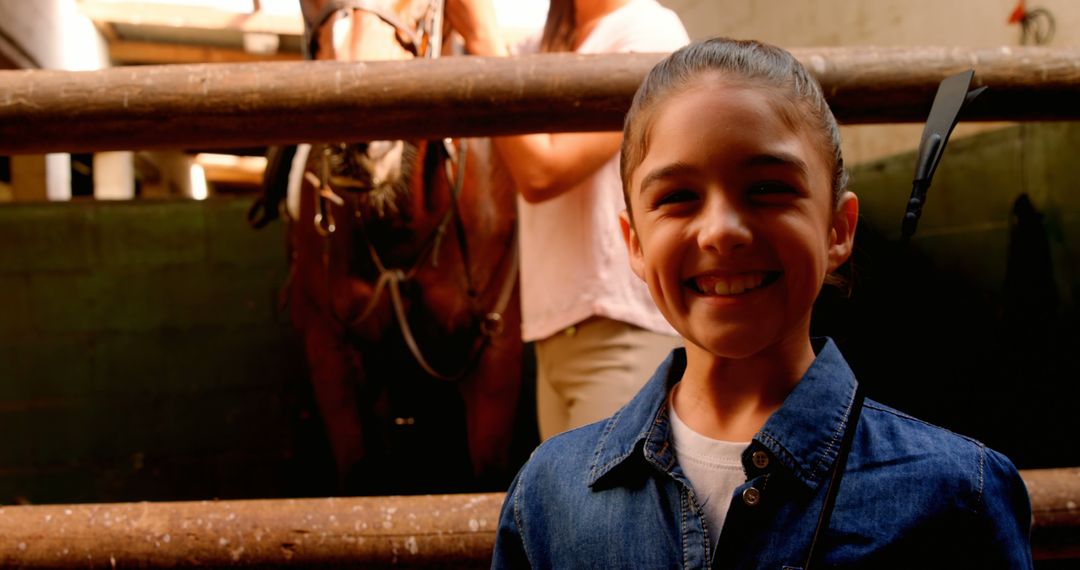 Young Girl Smiling in Stable with Horse