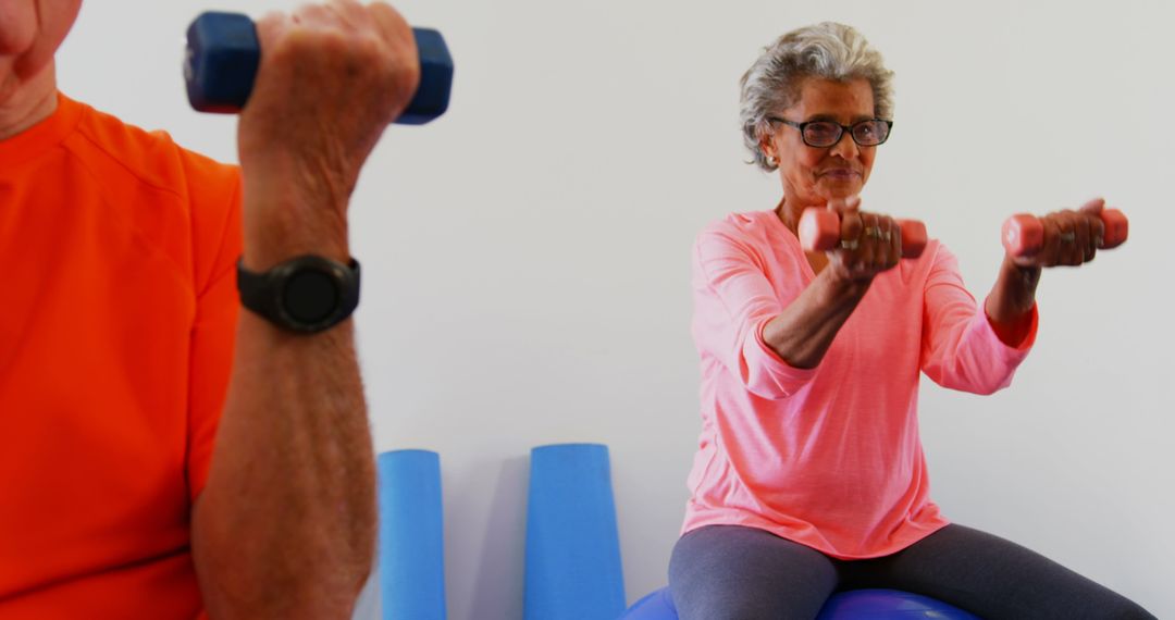 Senior Adults Exercising with Dumbbells in Fitness Studio