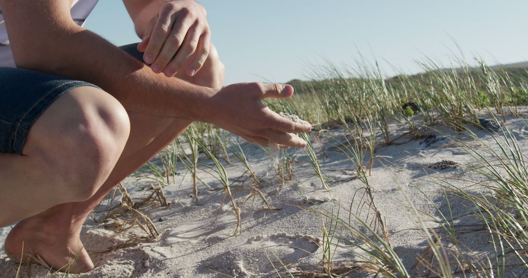 Hands Sifting Through Sand on Grassy Dunes - Free Images, Stock Photos and Pictures on Pikwizard.com