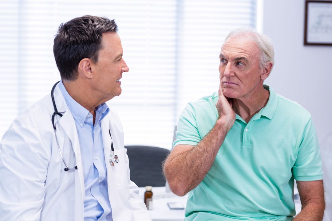 Senior man showing neck pain to doctor - Free Images, Stock Photos and Pictures on Pikwizard.com