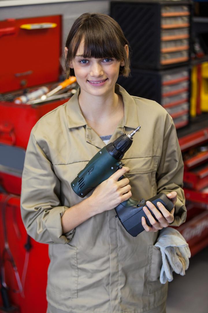 Female mechanic with pneumatic wrench - Free Images, Stock Photos and Pictures on Pikwizard.com