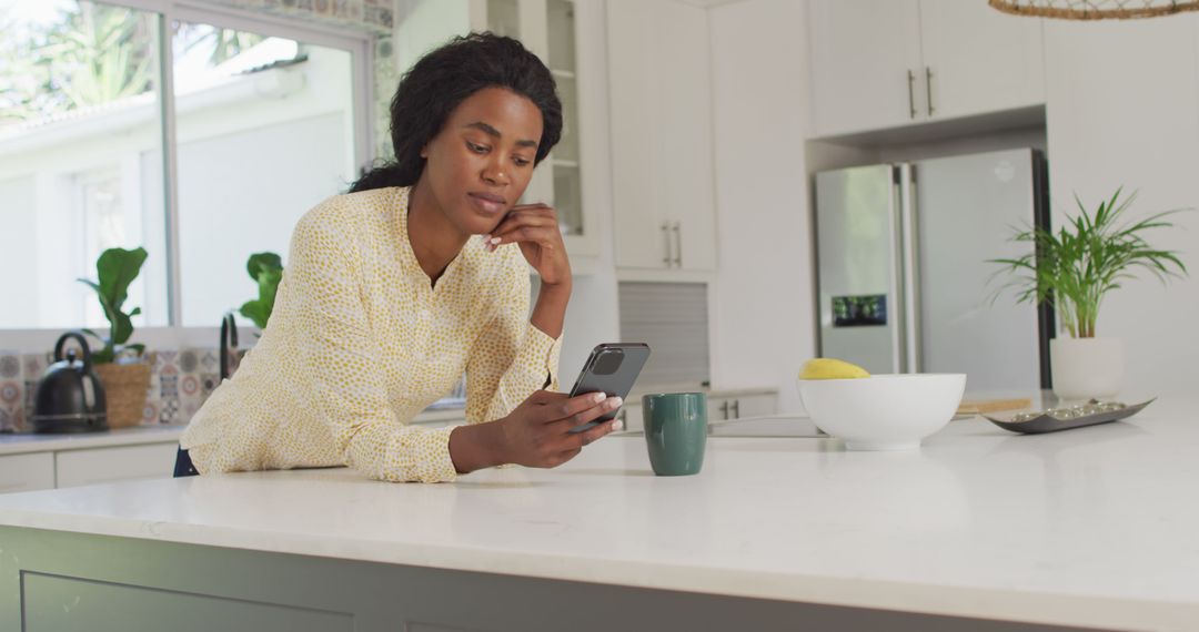 Image of african american woman using smartphone in kitchen - Free Images, Stock Photos and Pictures on Pikwizard.com