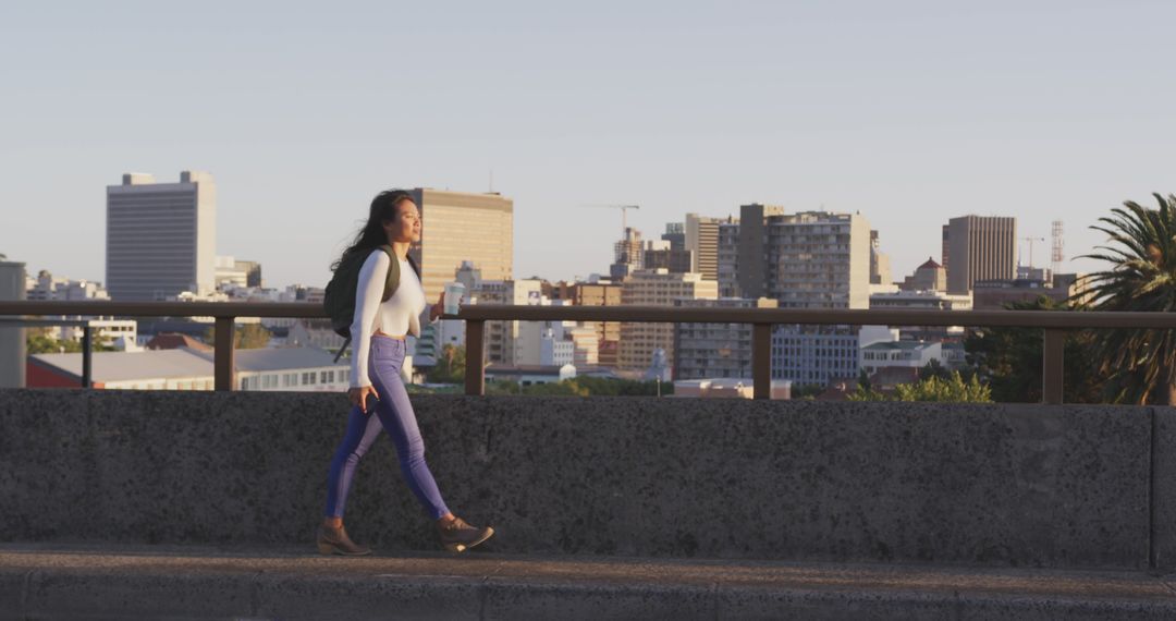 Urban Woman Walking Across City Bridge at Sunset - Free Images, Stock Photos and Pictures on Pikwizard.com