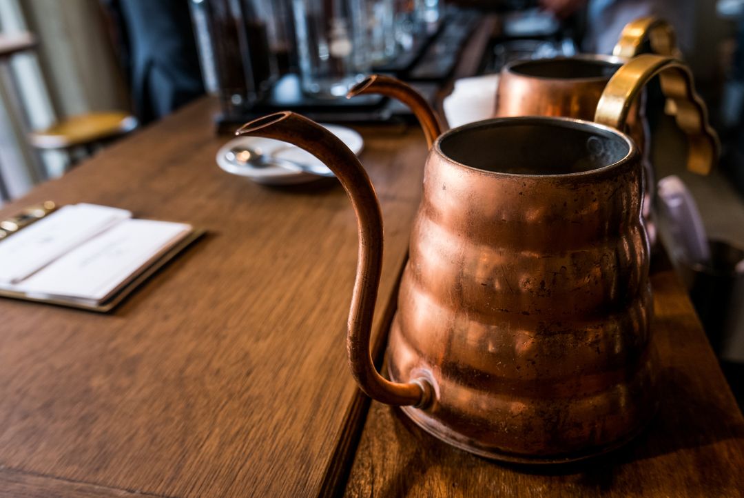 Copper Kettles on Rustic Wooden Table in Café