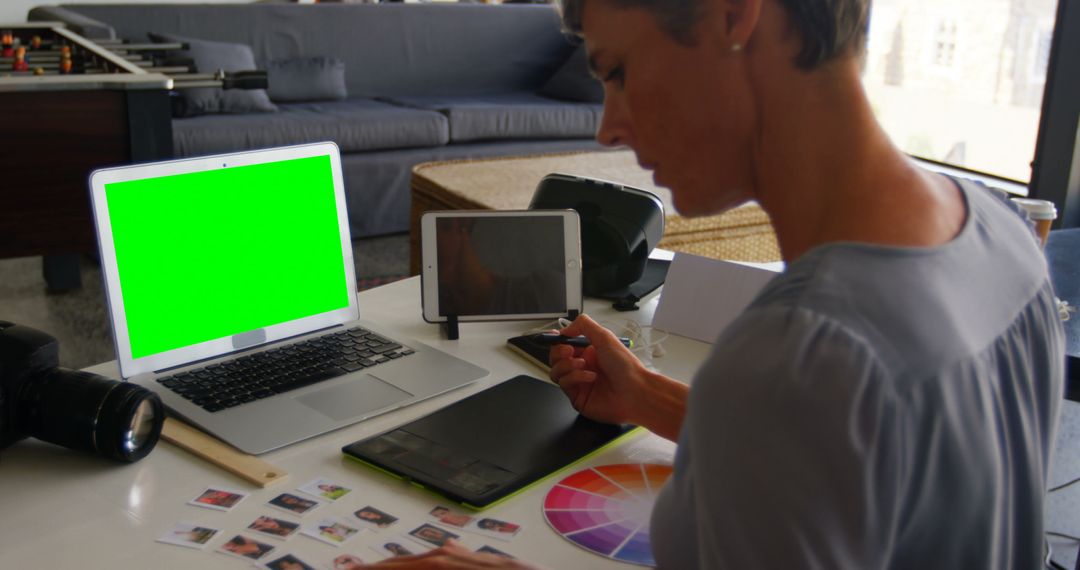 Graphic Designer Using Laptop with Green Screen and Tablet - Free Images, Stock Photos and Pictures on Pikwizard.com