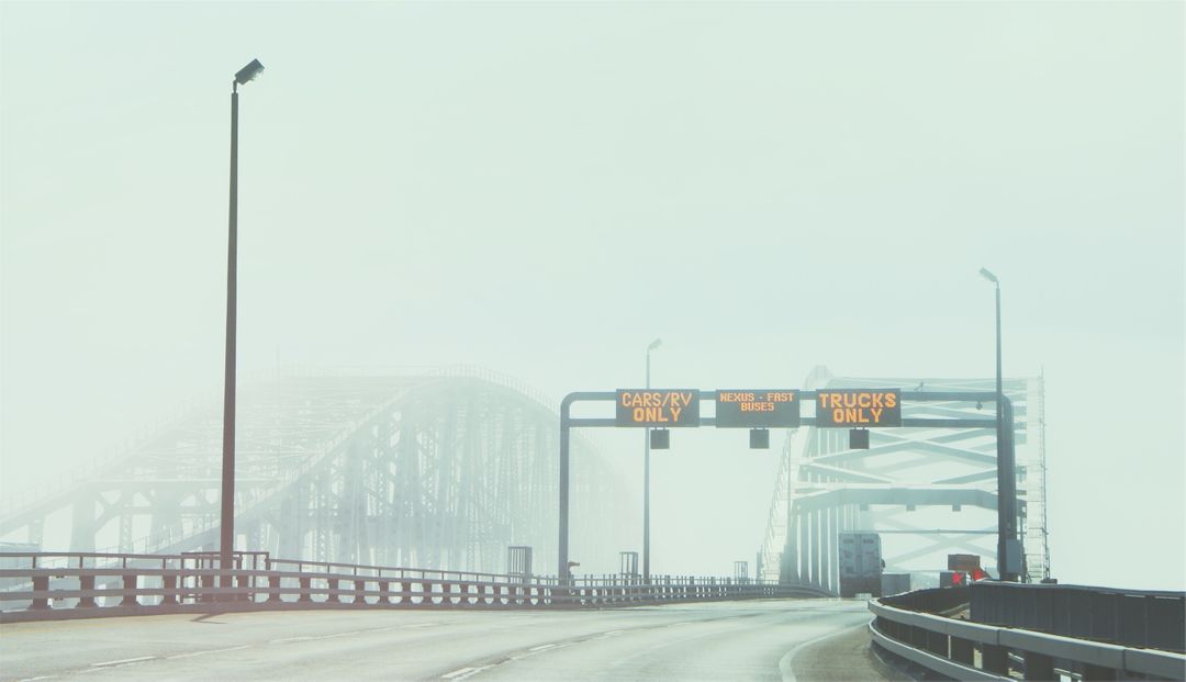 Foggy Highway Bridge with Directional Signs and Few Vehicles - Free Images, Stock Photos and Pictures on Pikwizard.com