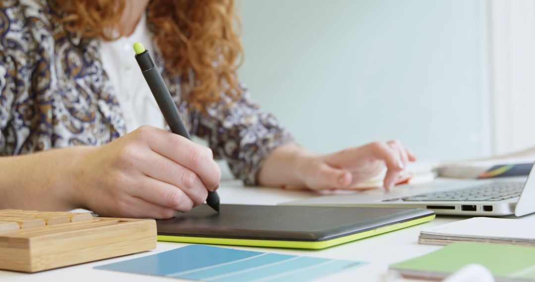 Designer Using Tablet with Color Swatches in Creative Workplace
