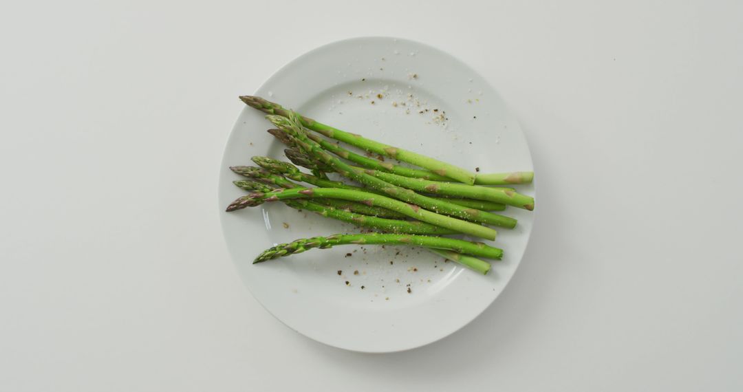 Image of fresh asparagus stalks on white plate over white background - Free Images, Stock Photos and Pictures on Pikwizard.com