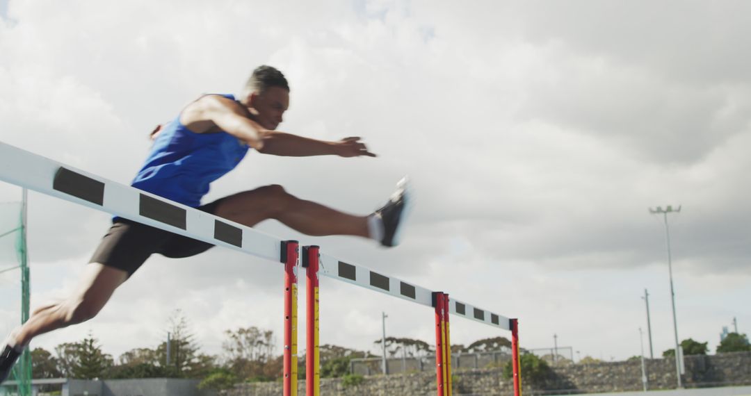 Athlete in Mid-air During Hurdle Jump on Track - Free Images, Stock Photos and Pictures on Pikwizard.com