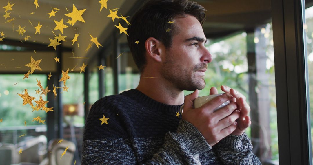 Man Pondering by Window Holding Coffee with Overlayed Gold Stars