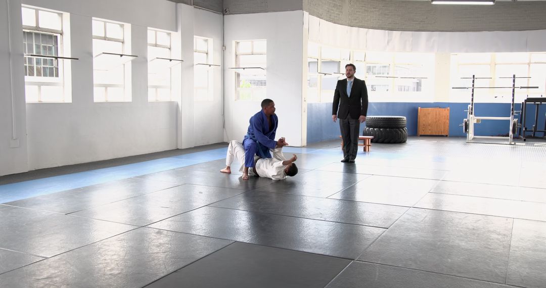 Martial Artists Sparring in Spacious Gym with Instructor
