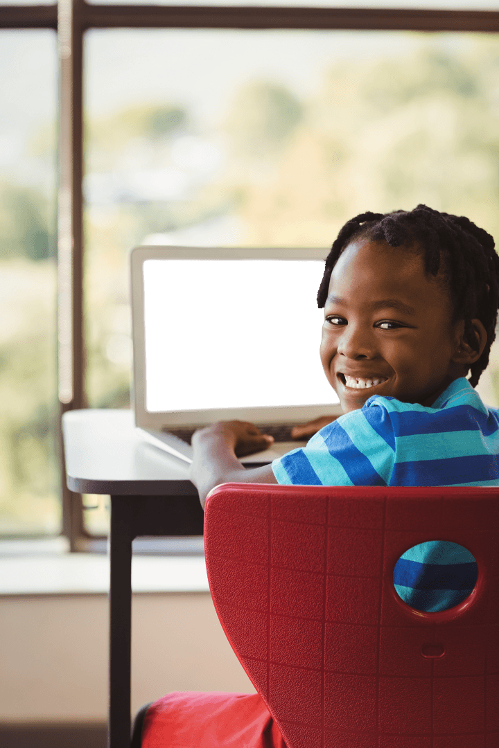 Young Boy Smiling in Front of Transparent Laptop Screen