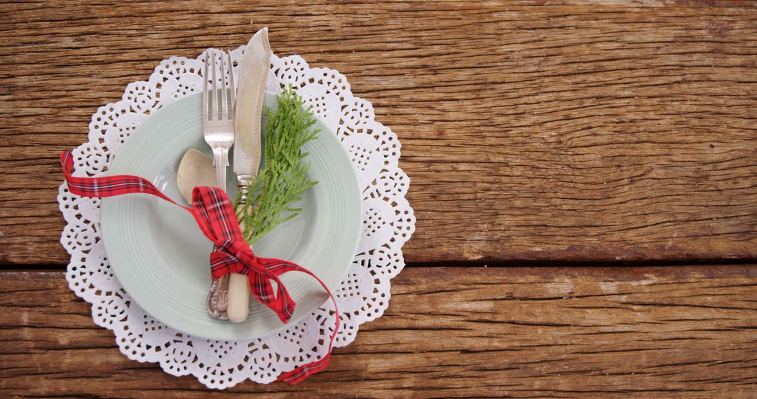 Rustic Holiday Table Setting with Red Ribbon and Greenery - Free Images, Stock Photos and Pictures on Pikwizard.com