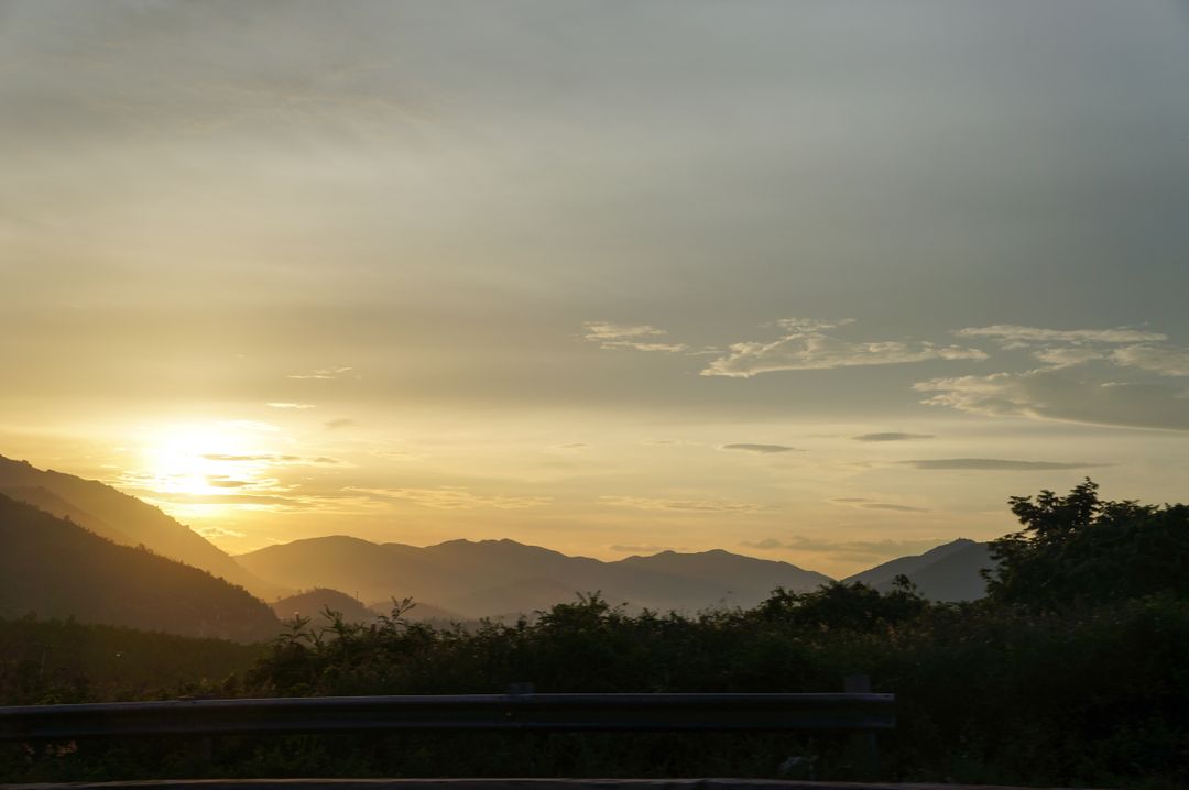 Serene Sunset Over Mountain Ranges with Trees in Foreground - Free Images, Stock Photos and Pictures on Pikwizard.com