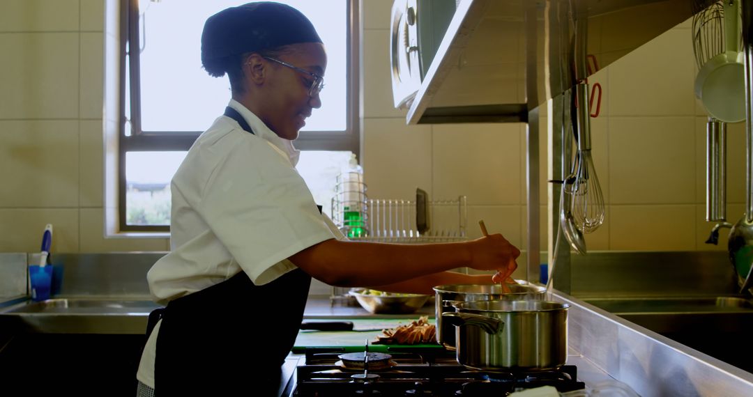 Young Chef Preparing Meal with Focused Precision in Professional Kitchen