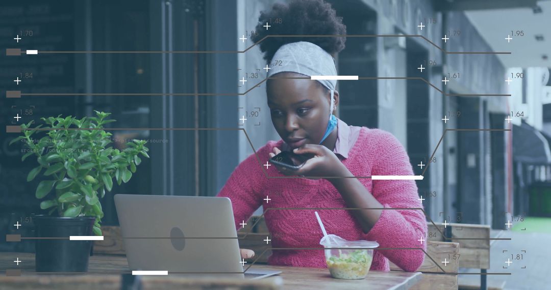Woman Multitasking with Smartphone and Laptop at Outdoor Cafe