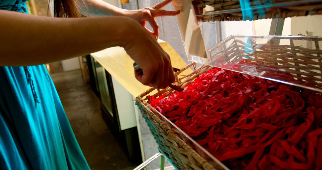 Woman creating ribbon decorations with baskets of colorful material - Free Images, Stock Photos and Pictures on Pikwizard.com