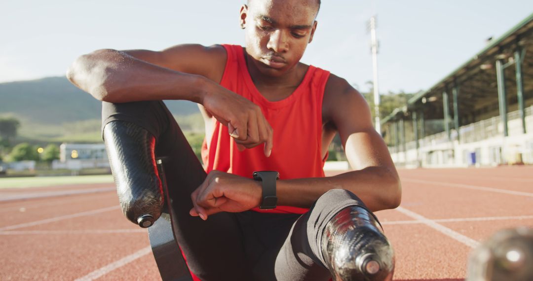 Male Athlete with Prosthetic Legs Checking Smartwatch on Running Track - Free Images, Stock Photos and Pictures on Pikwizard.com