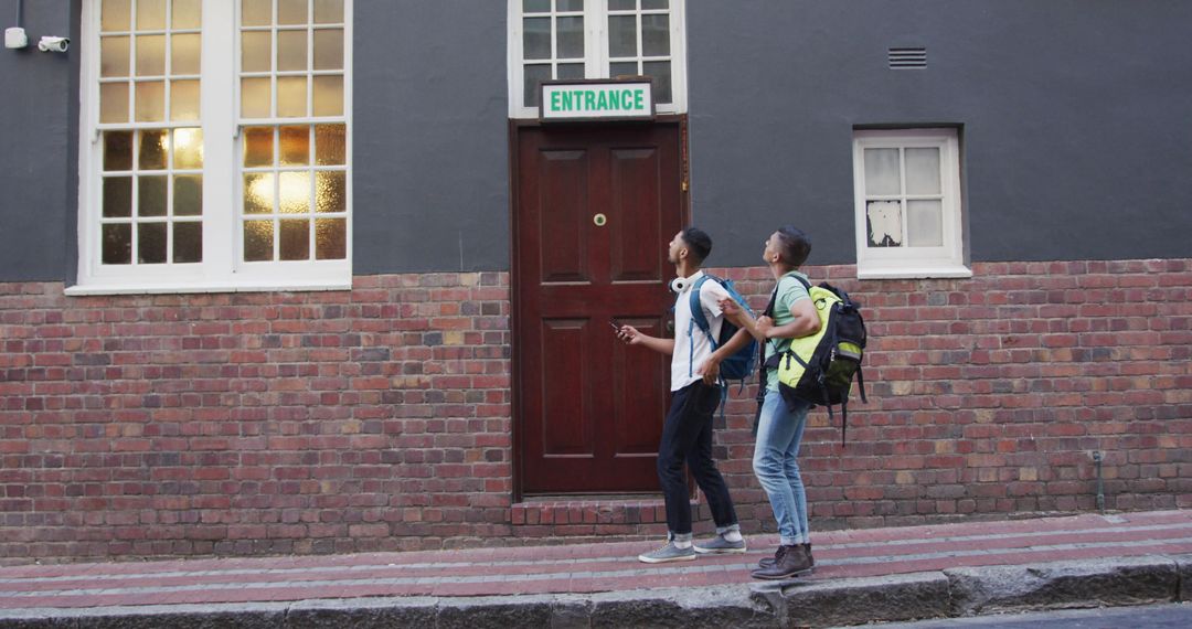 Backpacking Friends Exploring Urban Streets Seeking Hostel