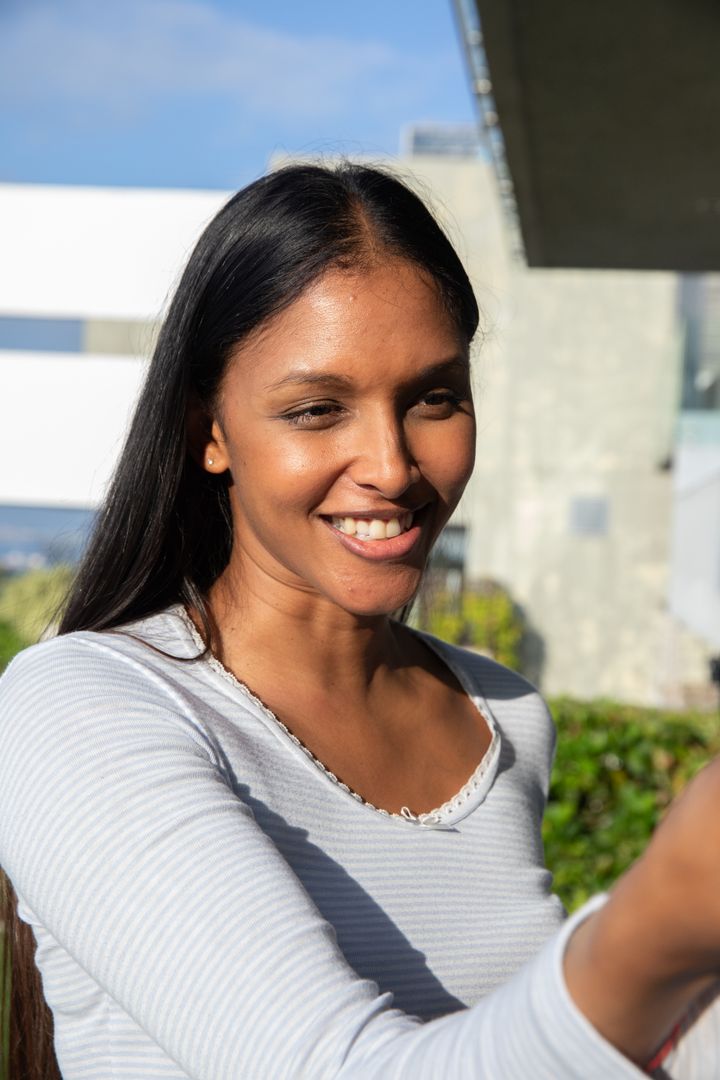 Smiling Woman Taking Selfie at Terrace with Modern Architecture