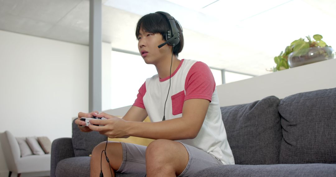 Focused Gamer Wearing Headset Playing Console Video Game