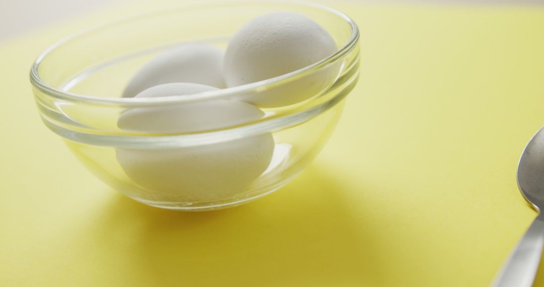 Close-up of Three Eggs in Clear Bowl on Yellow Background - Free Images, Stock Photos and Pictures on Pikwizard.com