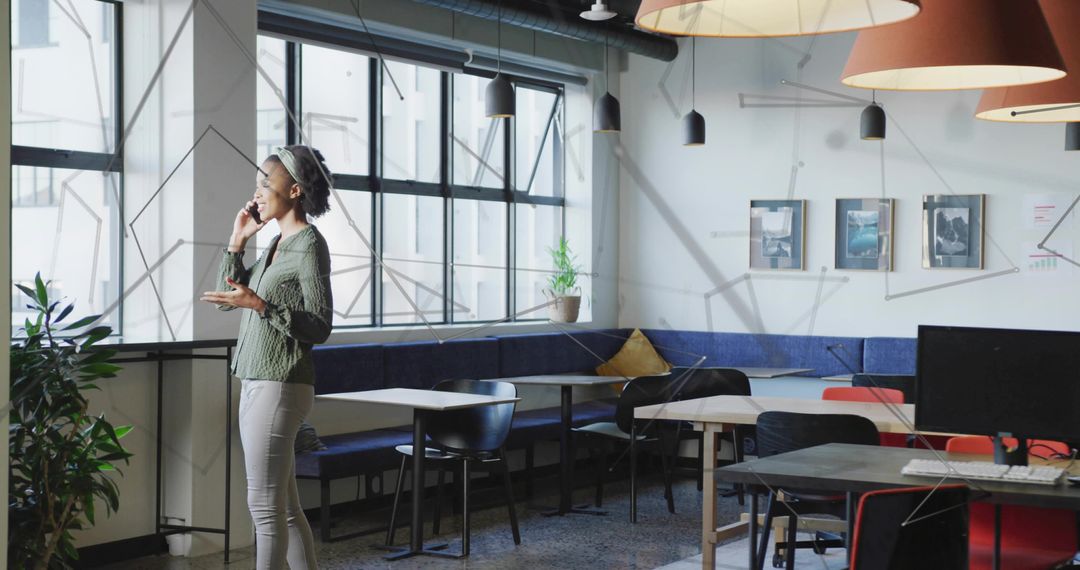 Confident Professional Woman Holding Smartphone in Modern Open Office